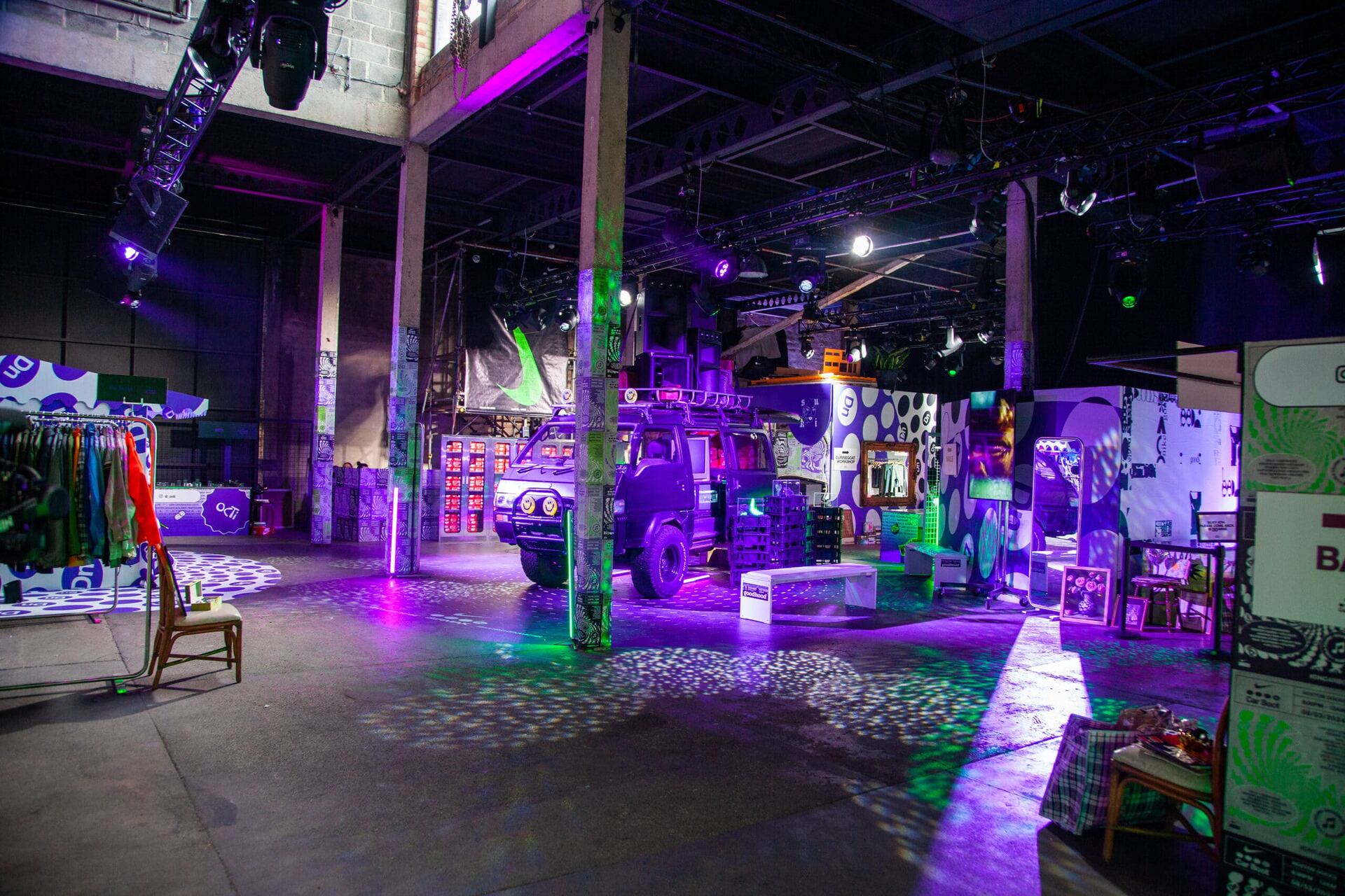 A van inside a building being illuminated with purple and green lighting.